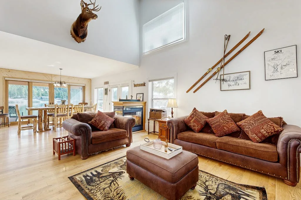 Una sala luminosa con asientos marrones y un comedor junto a las ventanas.