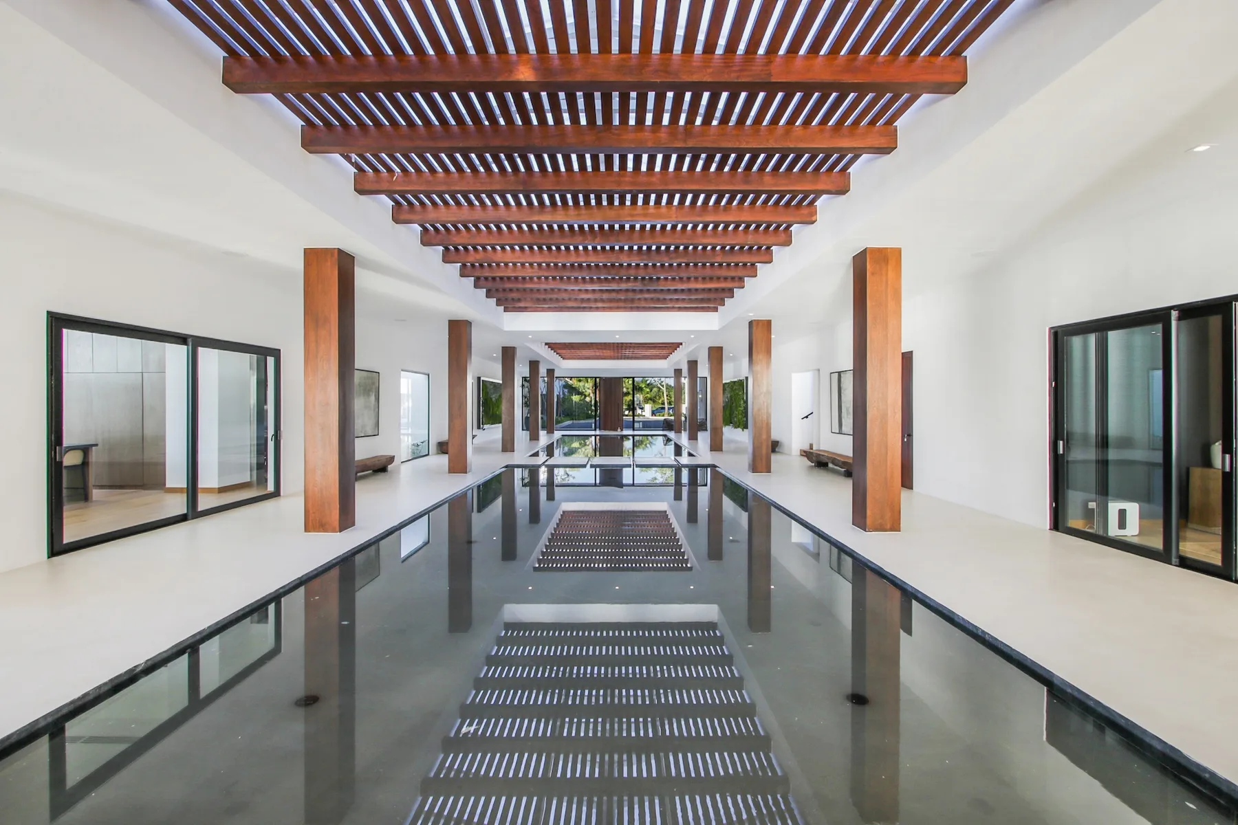 A long indoor water feature runs through a bright corridor beneath a wooden slatted ceiling.