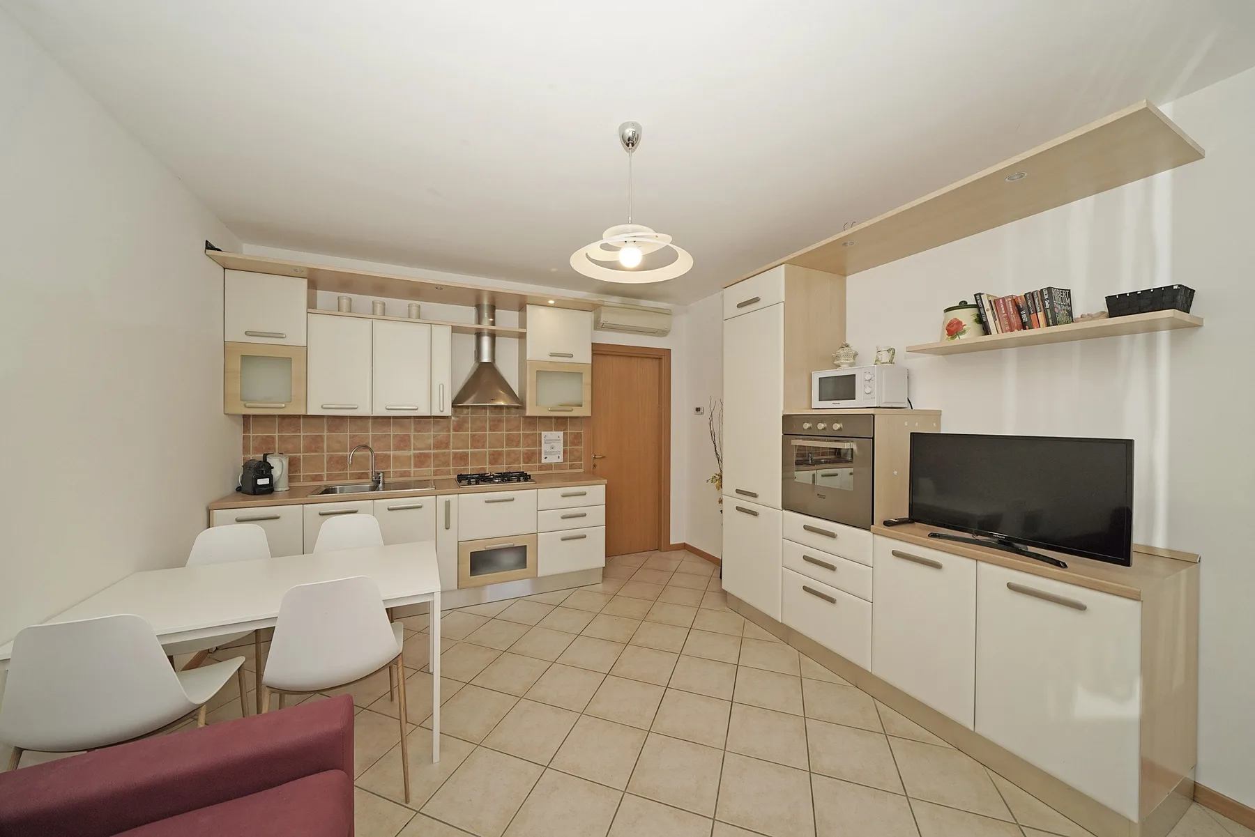 A bright kitchen and dining area with white cabinets and a table.
