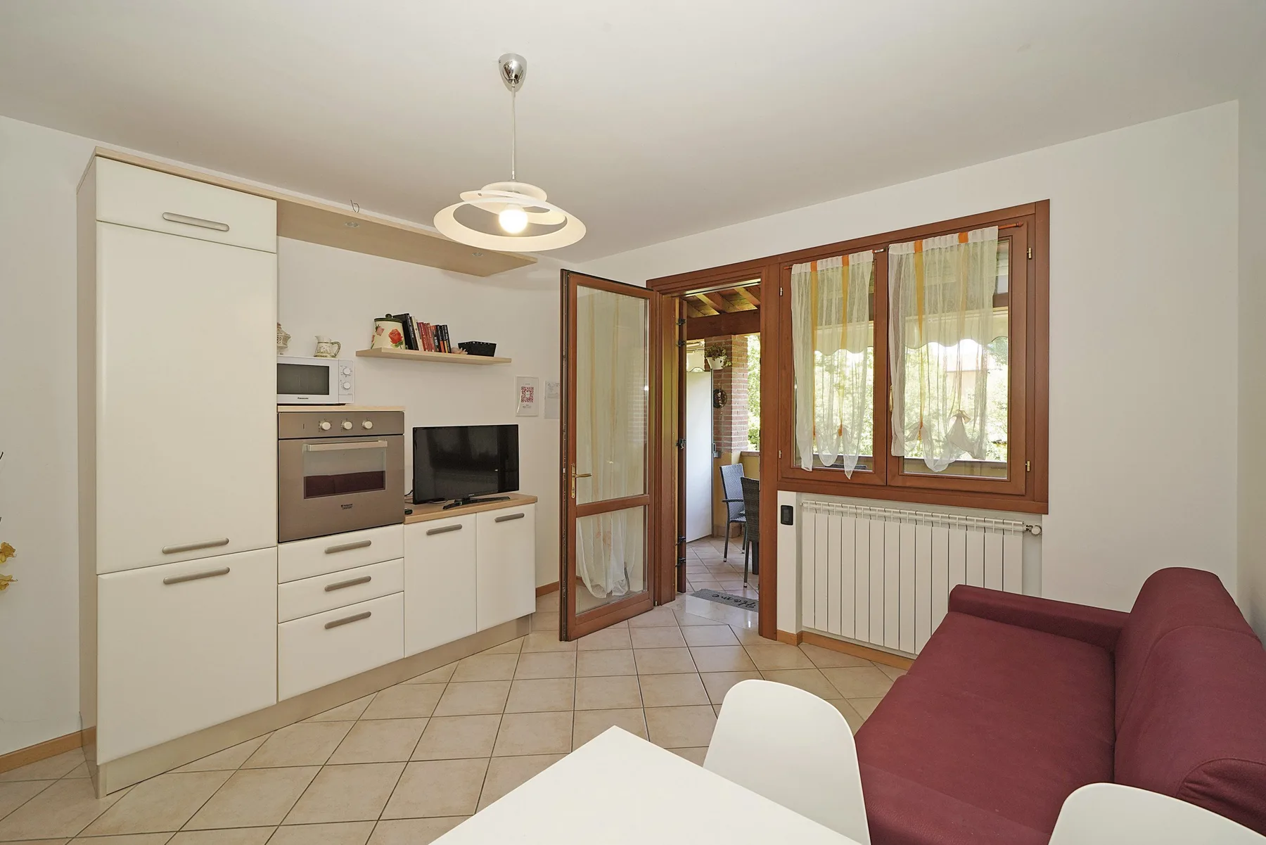 A bright kitchen and living area with a dining table and seating.