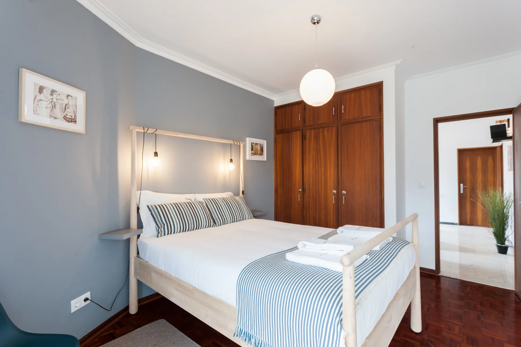 Un dormitorio con una cama bien tendida y armarios de madera.
