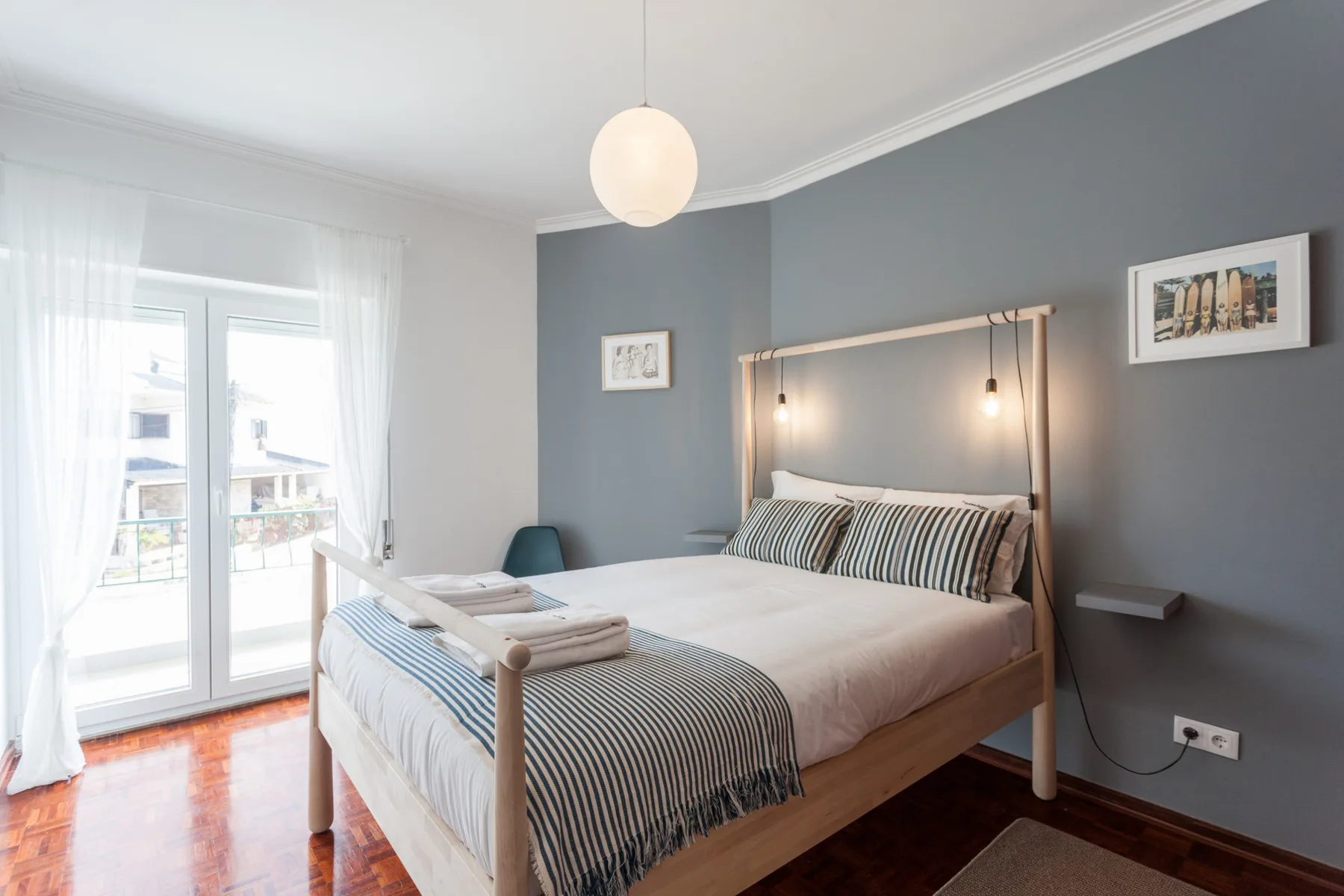 Un dormitorio con una cama bien hecha y una ventana luminosa.