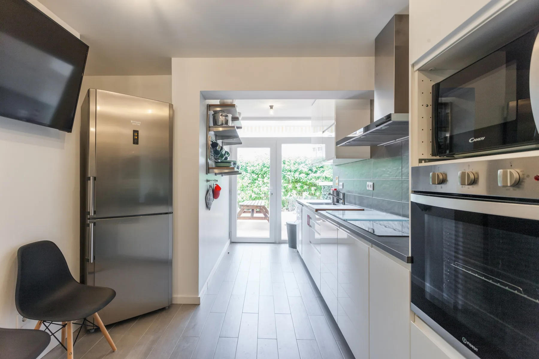 Una cocina luminosa con electrodomésticos de acero inoxidable y una mesa de comedor al fondo.