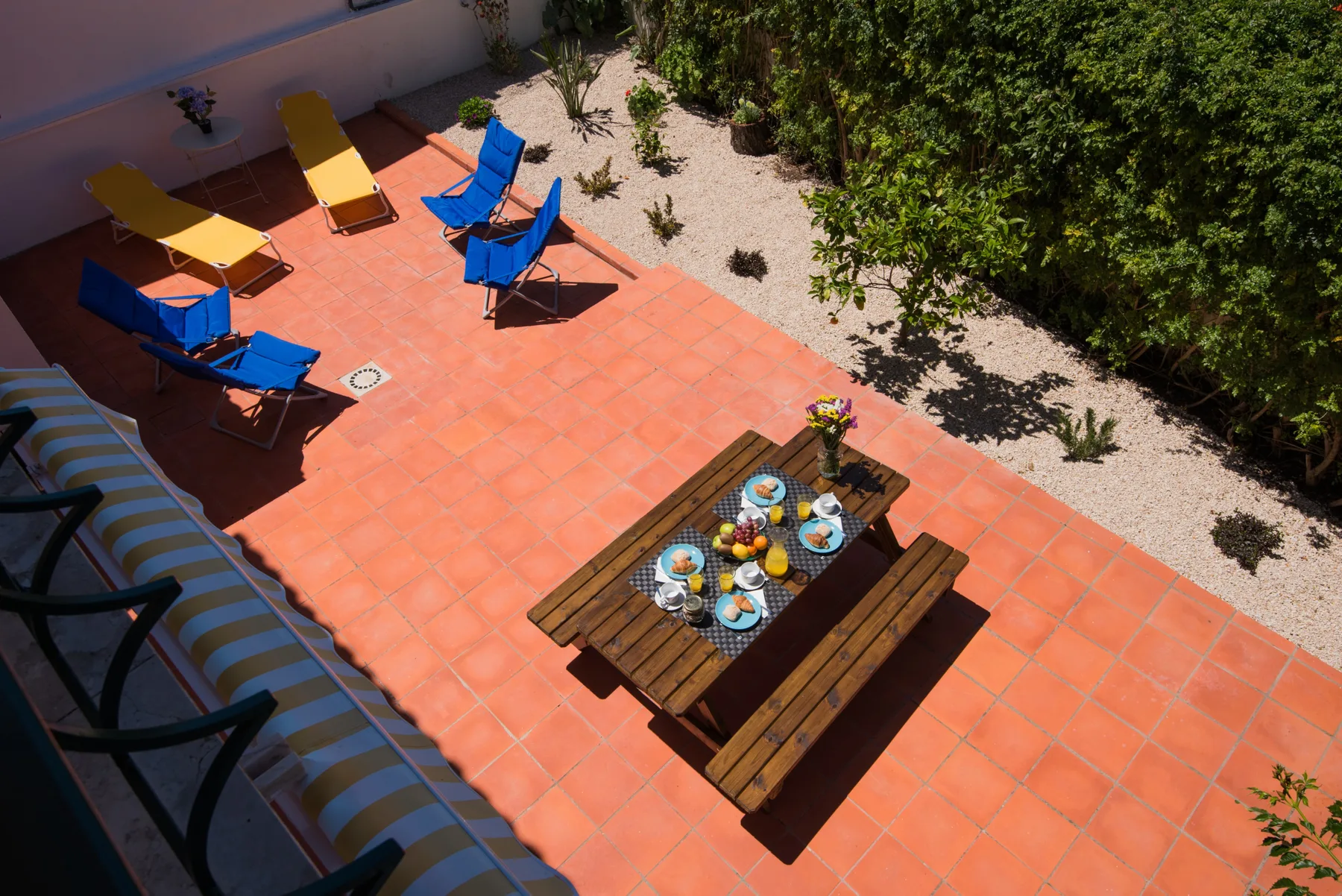 Un patio de baldosas con asientos al aire libre y una mesa de madera.