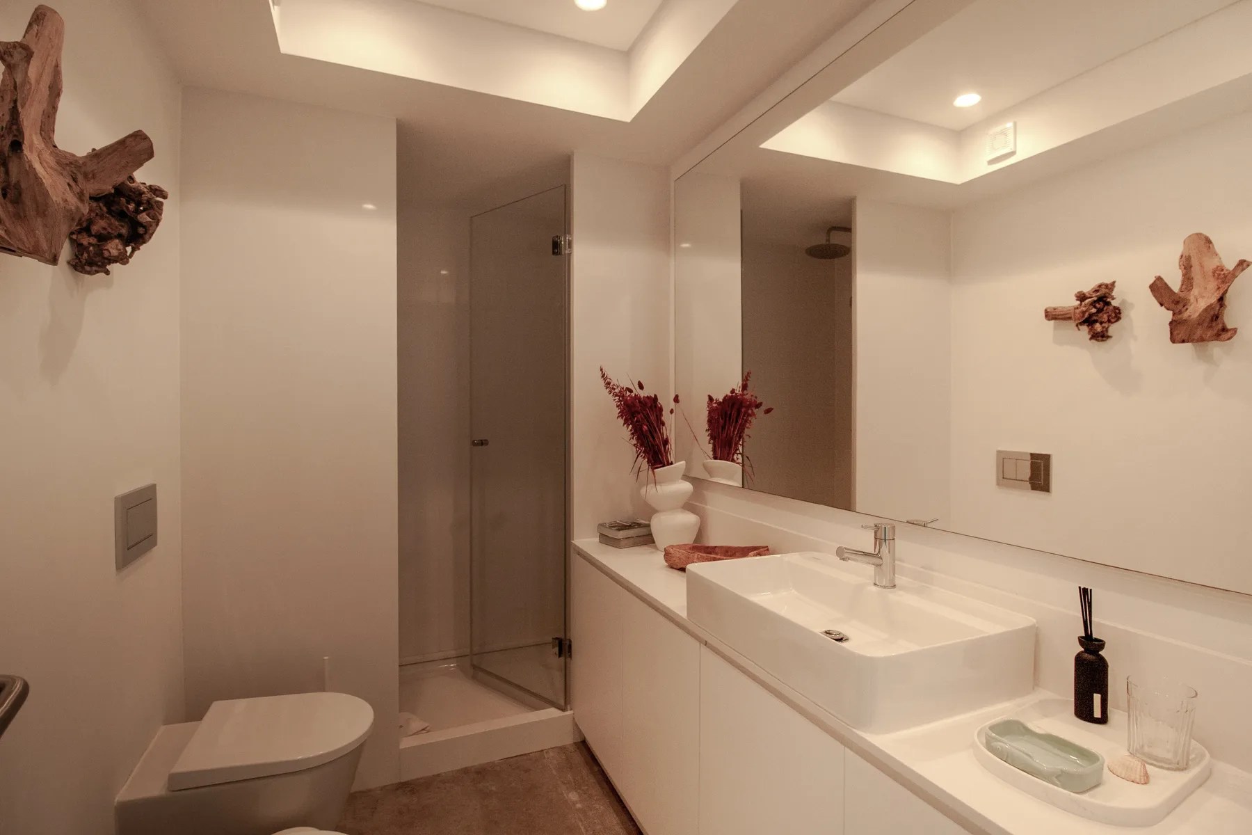 A bathroom with a long vanity, sink, and mirror.