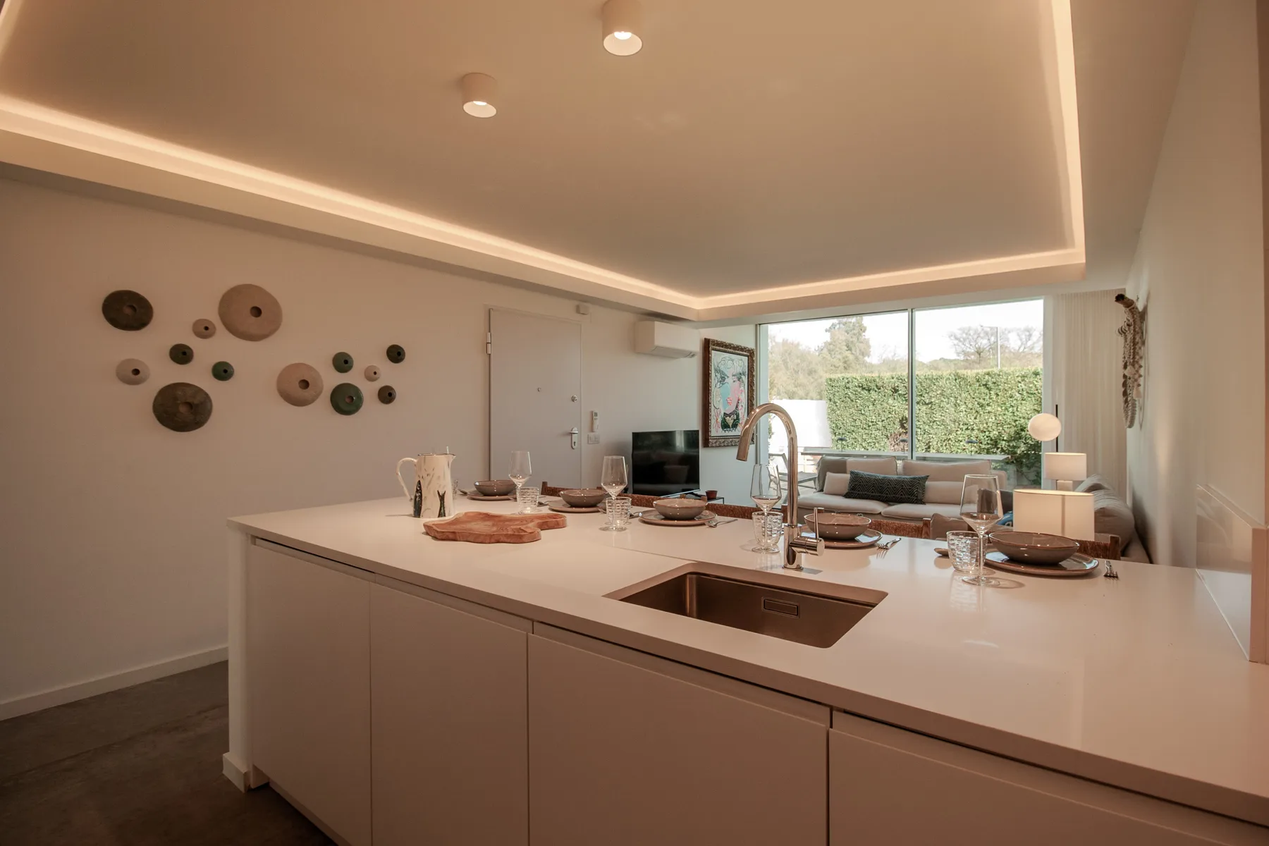 A modern kitchen with a large island and an open view into the living area.