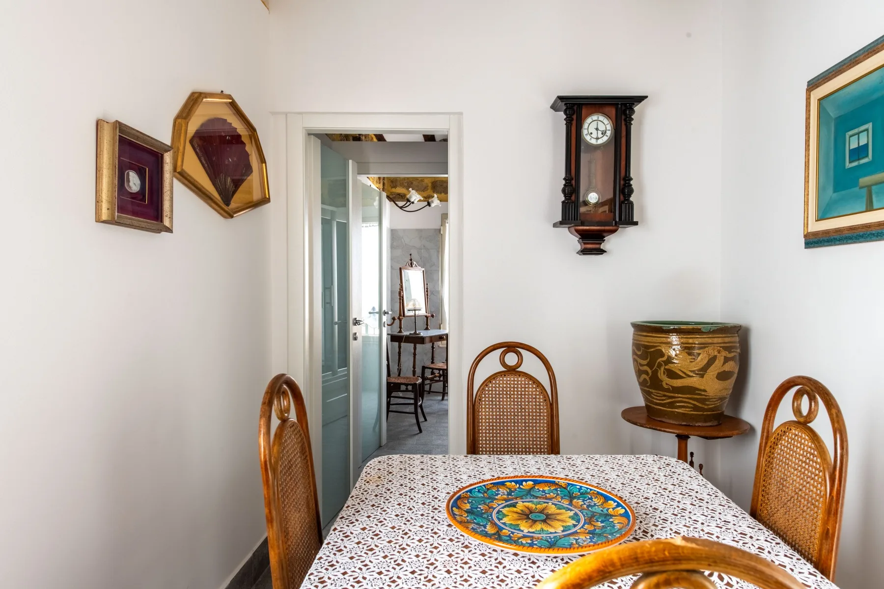 Un comedor con un mantel estampado y cuadros en las paredes.