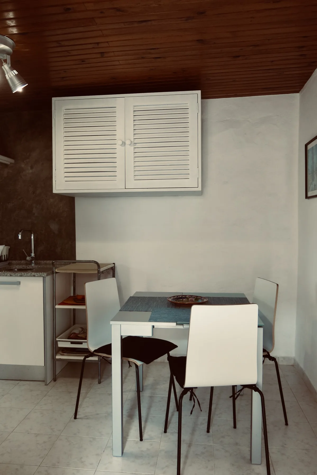 A dining area with a table and seating beside a compact kitchen.