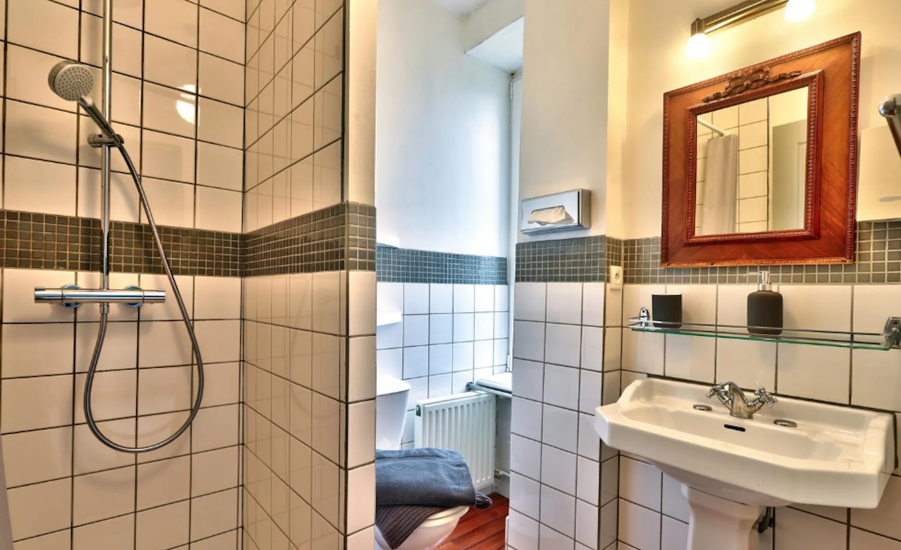 A tiled bathroom with a shower and sink.