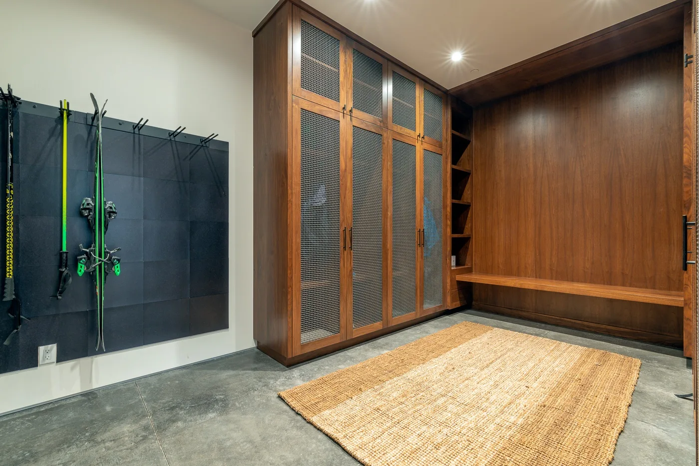 Un mueble de madera y equipo colgado enmarcan una alfombra en el suelo.