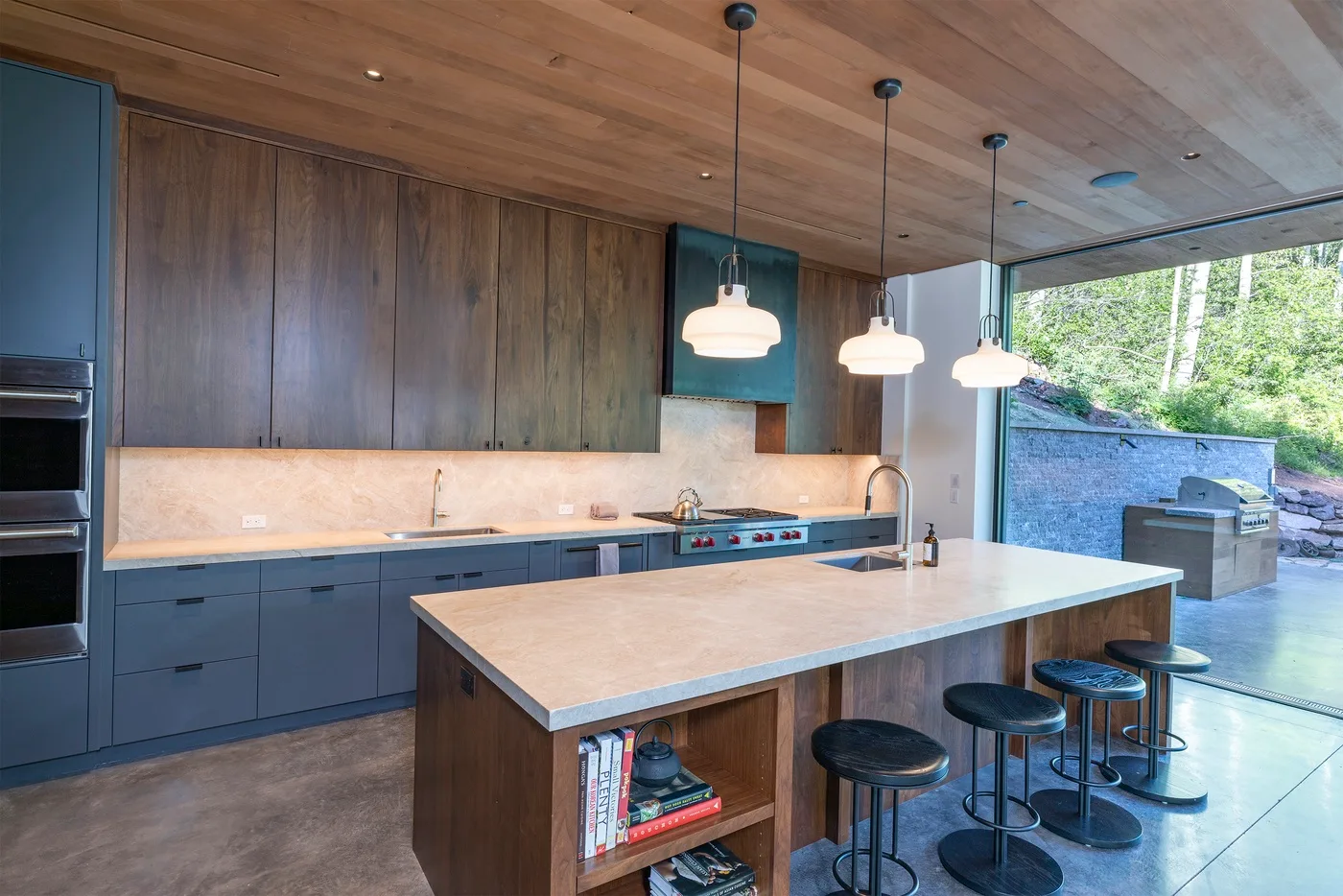 Una cocina moderna con una isla grande y lámparas colgantes.