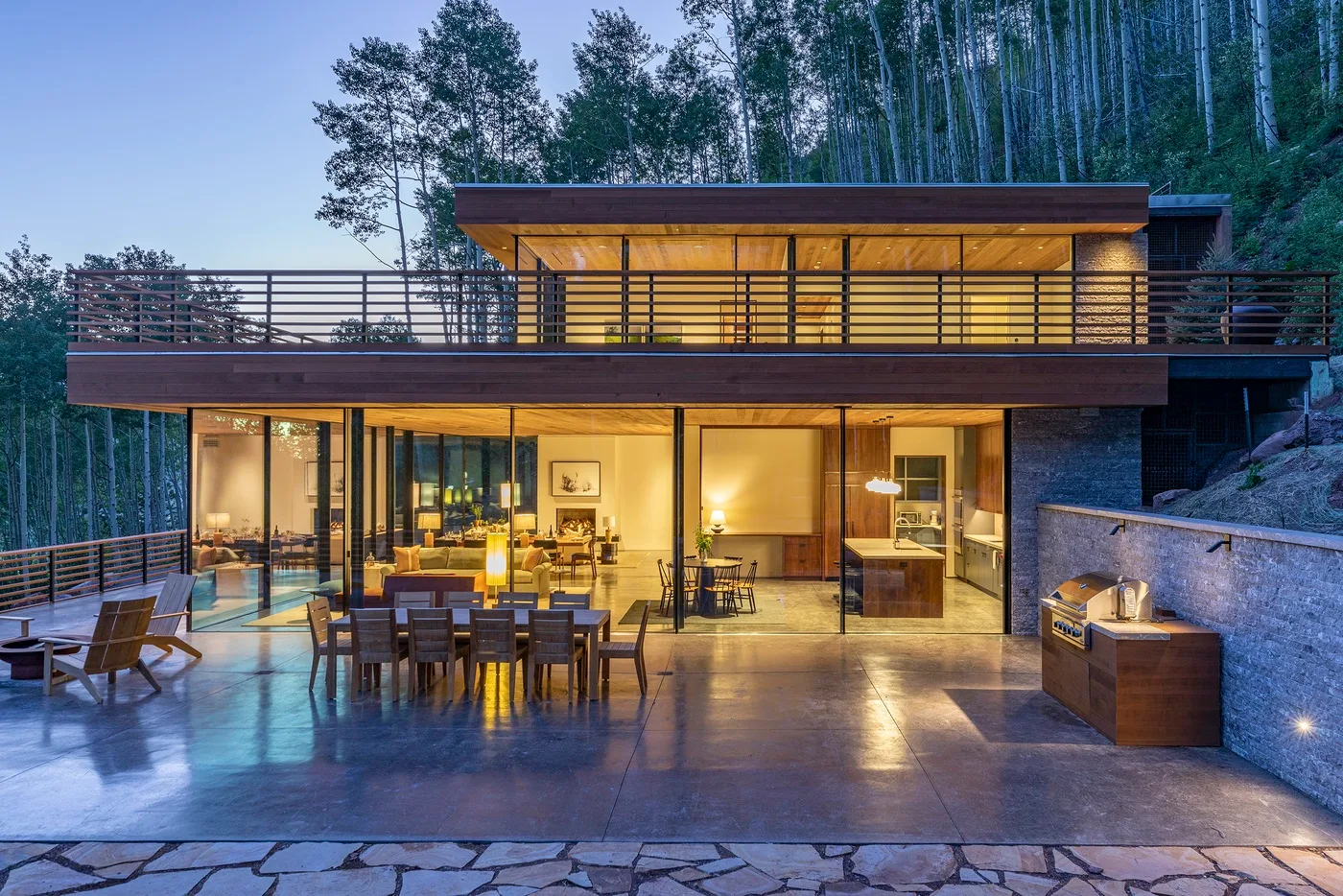 Una casa moderna se abre a un amplio patio con asientos al aire libre.