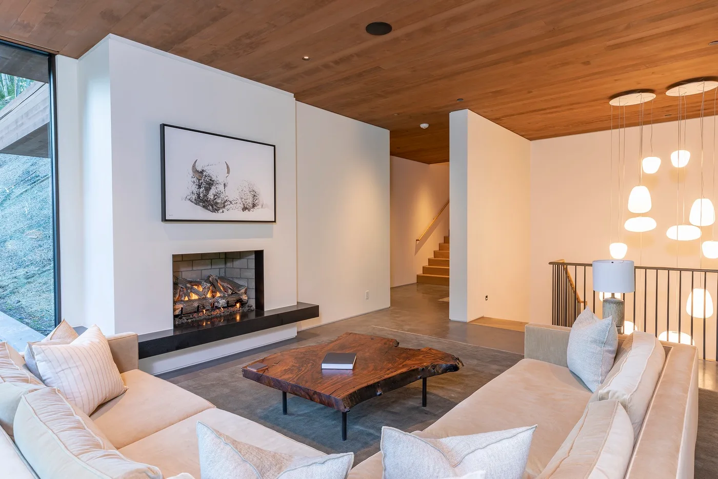 Una sala de estar con asientos alrededor de una mesa baja y una chimenea.