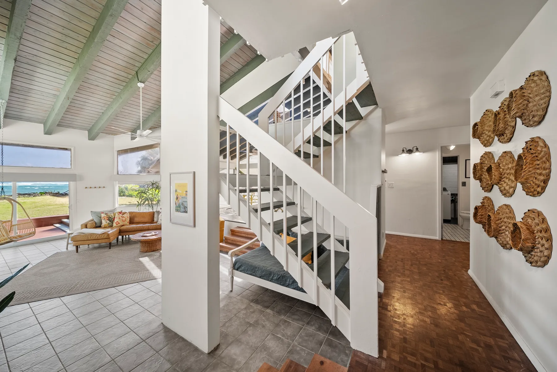 Una sala abierta con una escalera, asientos y adornos tejidos en la pared.