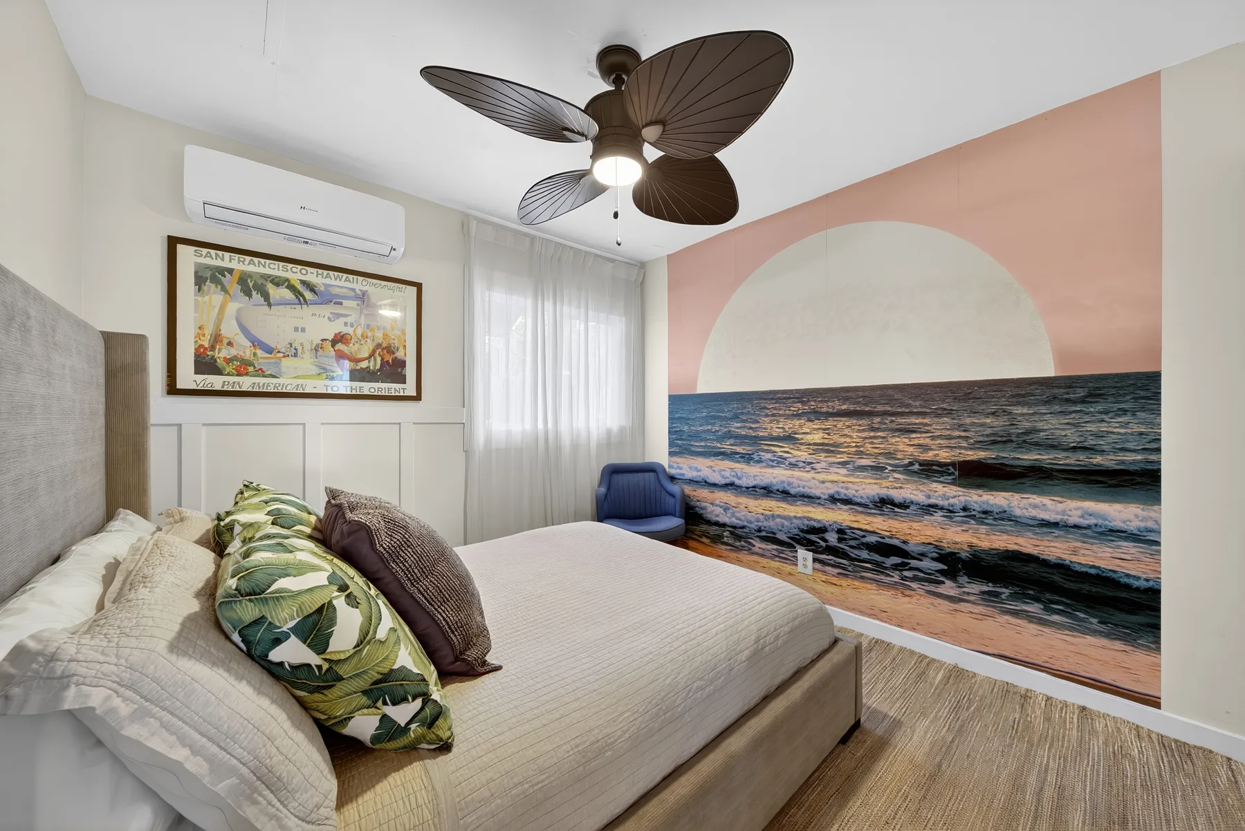 Un dormitorio con una cama y un mural de olas del océano.