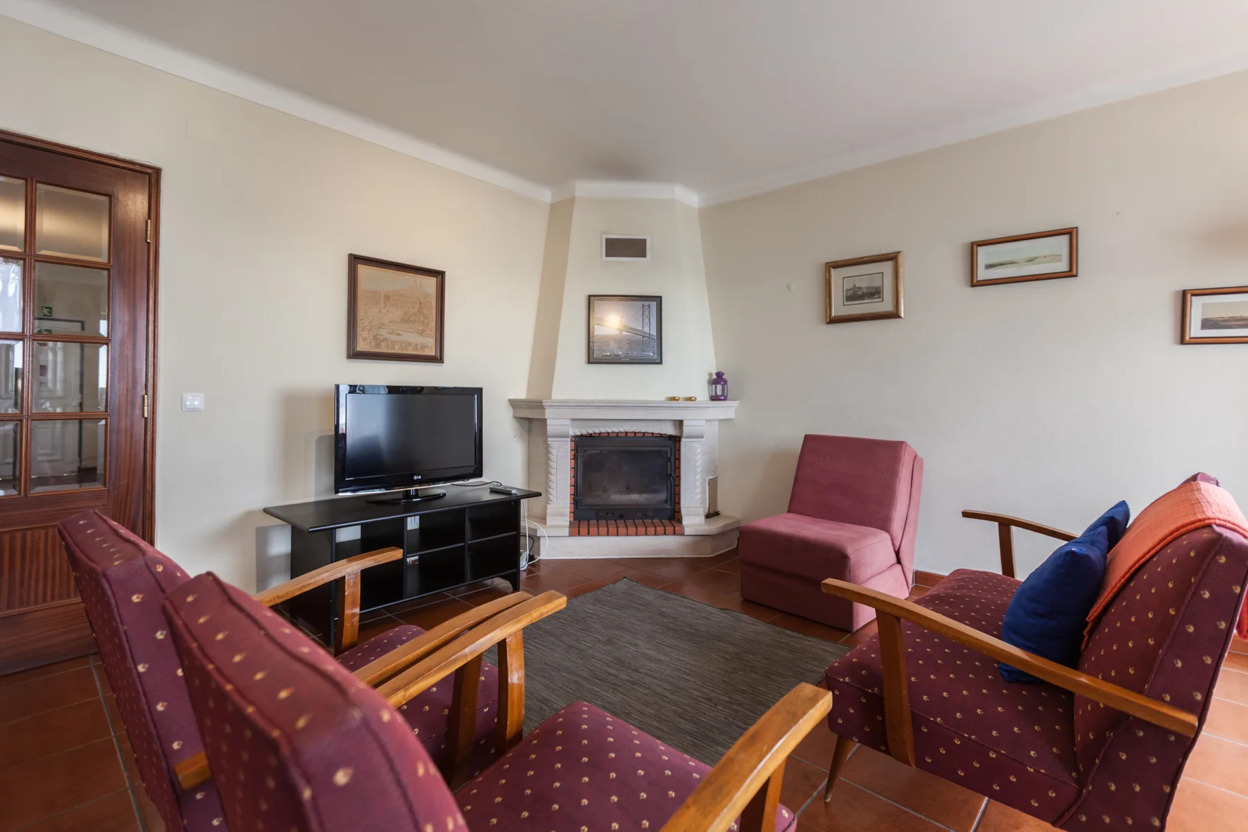 A living room with seating arranged around a television and fireplace.