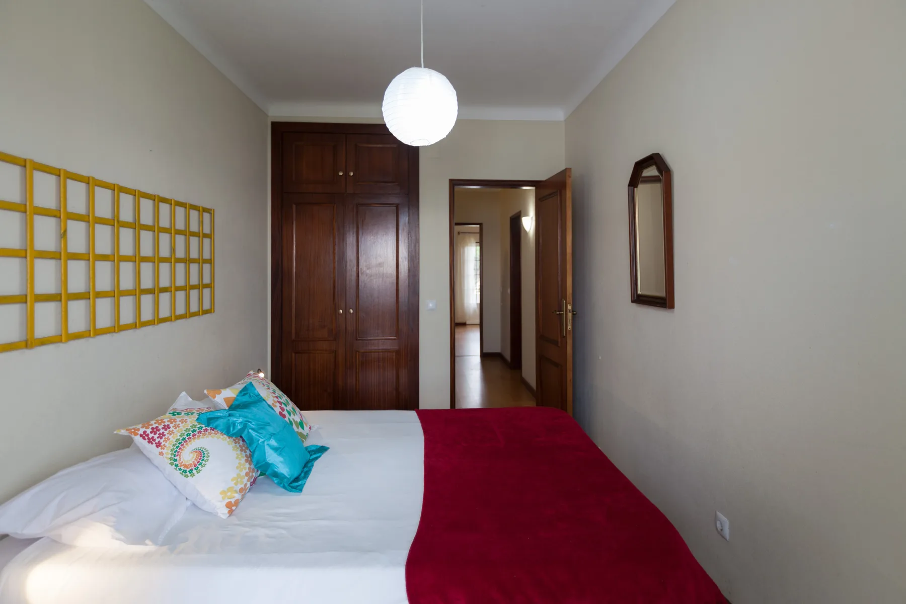 Un dormitorio con cama, armario y una puerta abierta.