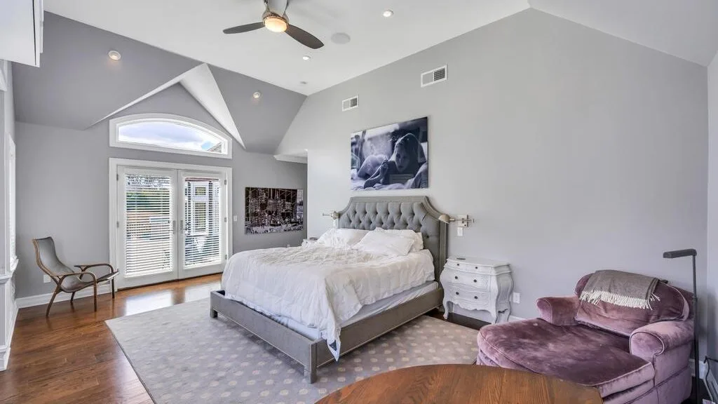 A bright bedroom with a large bed and seating area.