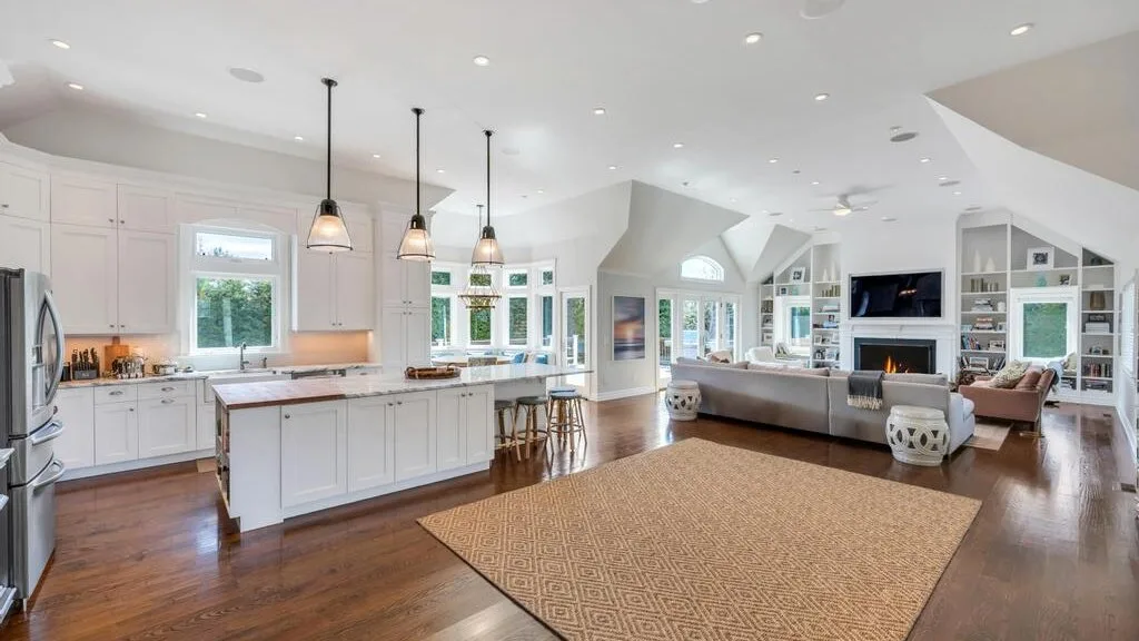 An open-plan kitchen and living area with a large woven rug.