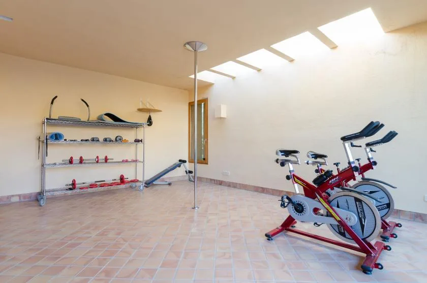 Una sala de ejercicio luminosa con bicicletas estáticas y equipo de entrenamiento.