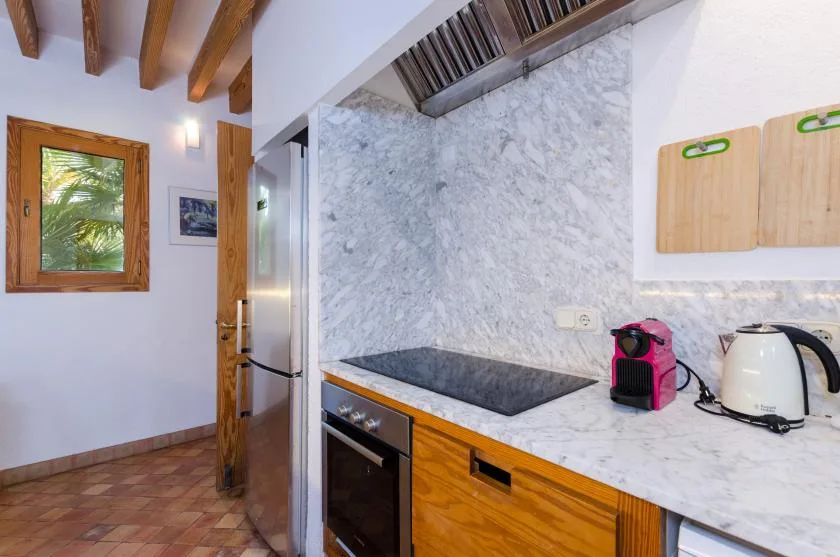 Una cocina con una placa oscura, armarios de madera y una encimera.