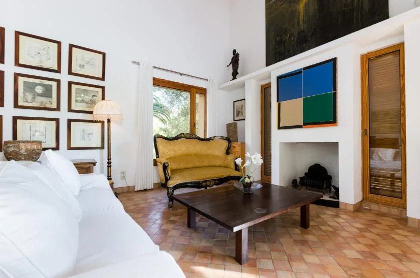 Una sala luminosa con asientos, una mesa de centro oscura y una chimenea.