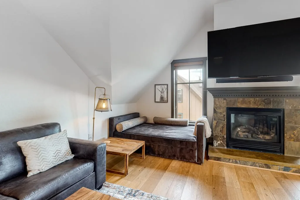 A living room with seating, a fireplace, and a television.