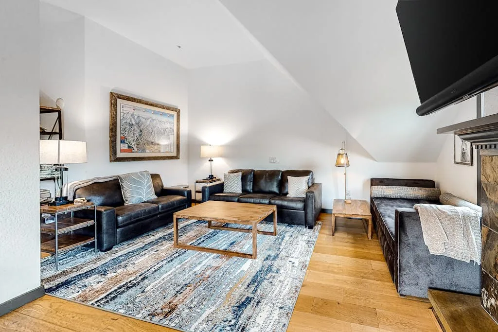 A bright living room with seating arranged around a wooden coffee table.