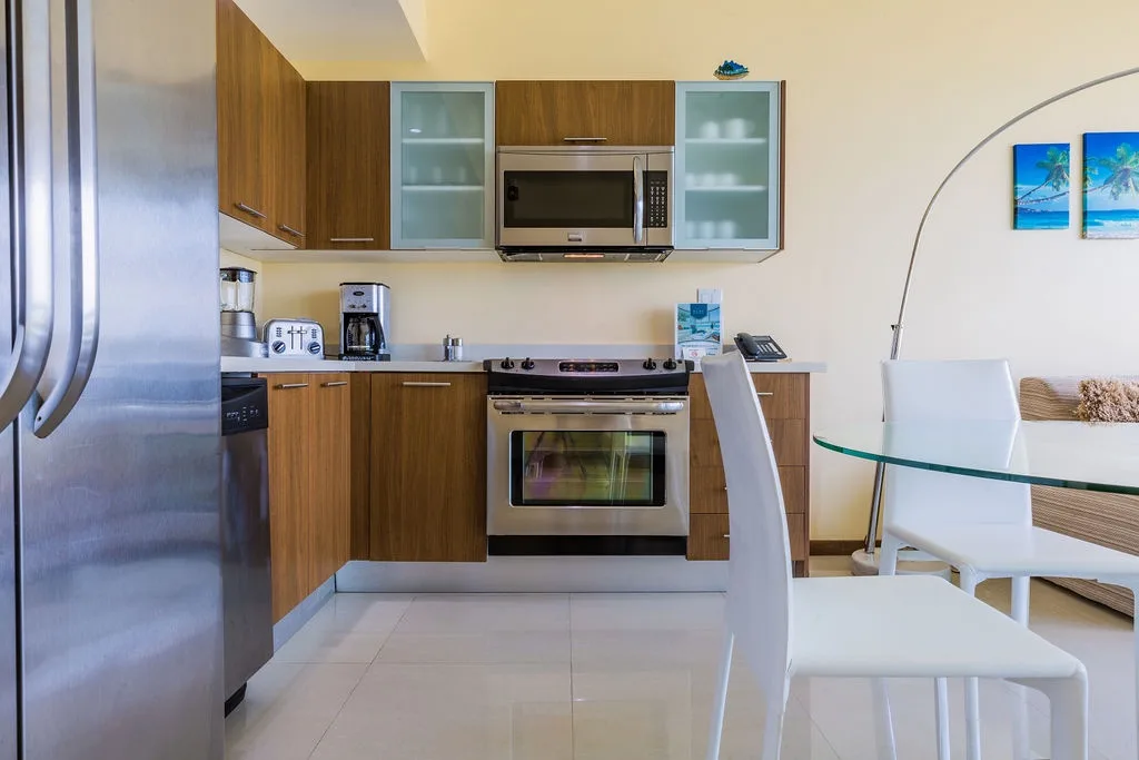 Your fully equipped modern kitchen invites you to prepare meals with stainless steel appliances, sleek wood cabinetry, and a bright dining area perfect for enjoying your morning coffee.