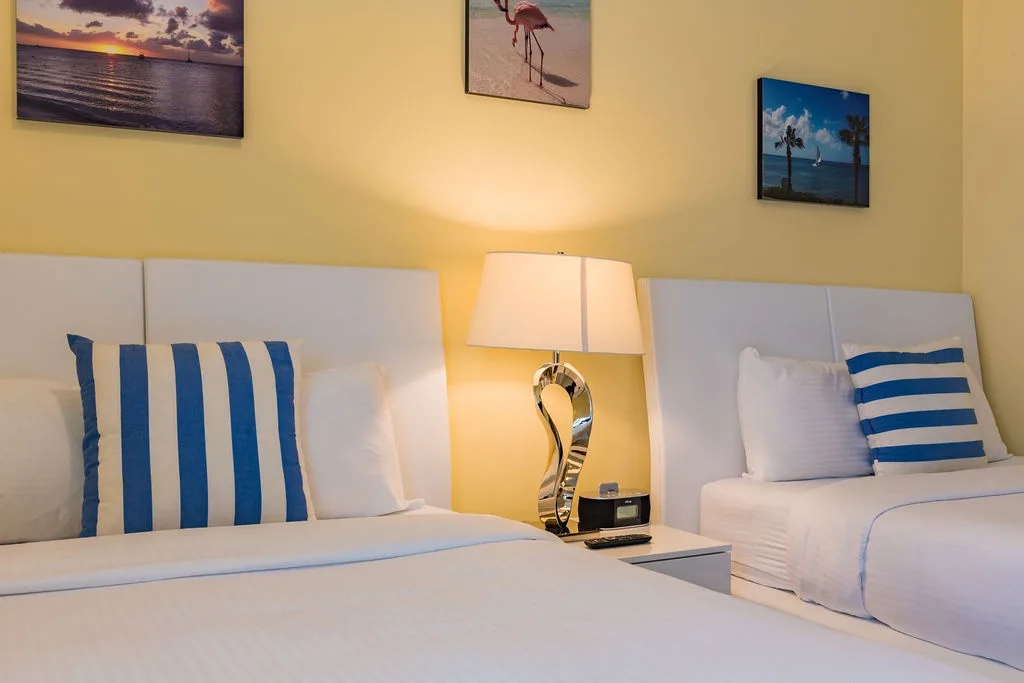 Your coastal retreat awaits with crisp white linens, cheerful beach-themed artwork, and a soothing blue-and-white palette that brings the ocean right to your room.