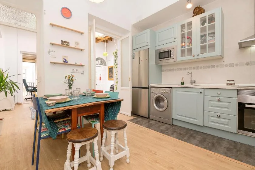 A bright kitchen and dining area with a table set beside the cabinets.