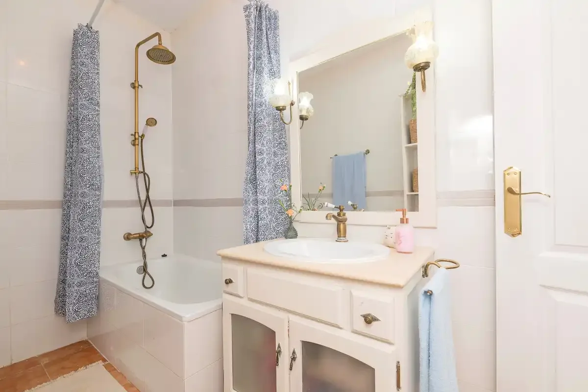 A bright bathroom with a bathtub, shower, and sink vanity.
