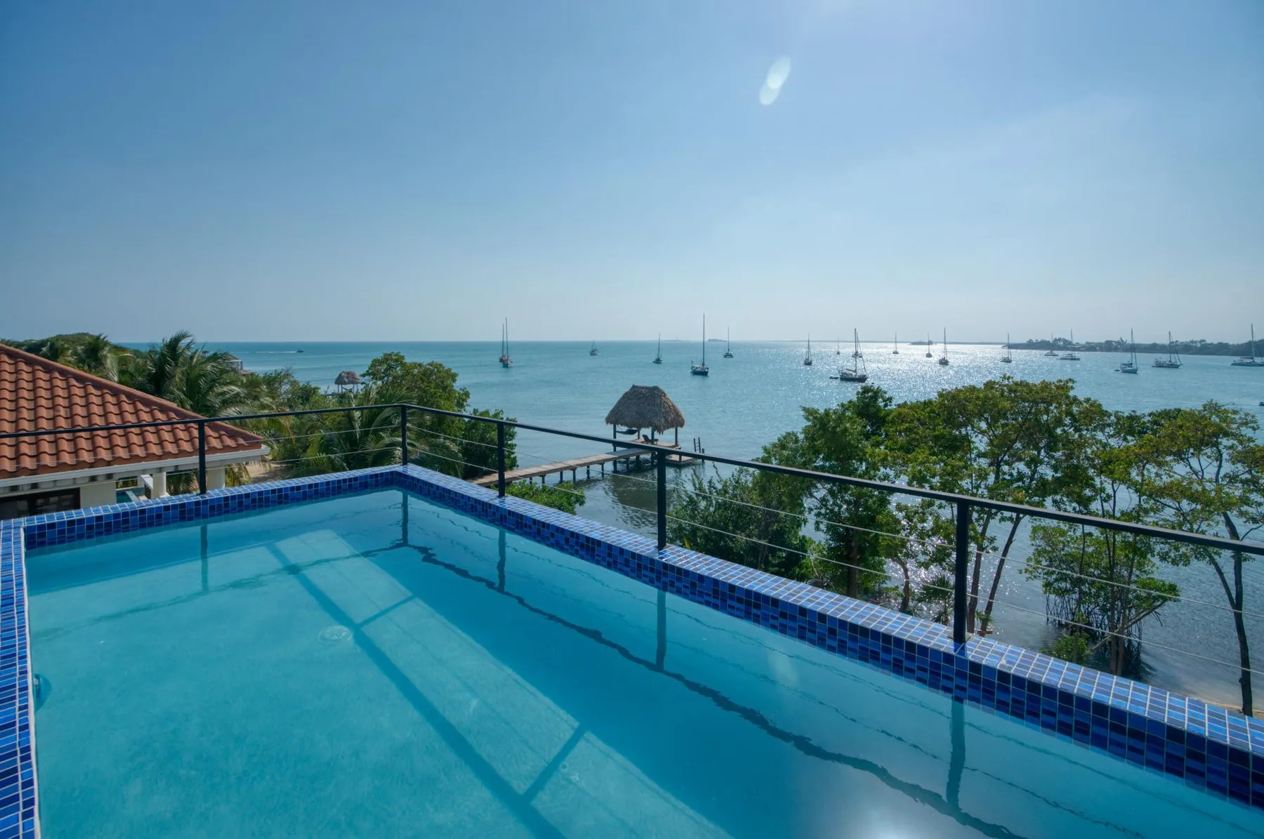 A swimming pool overlooks a bay dotted with sailboats.