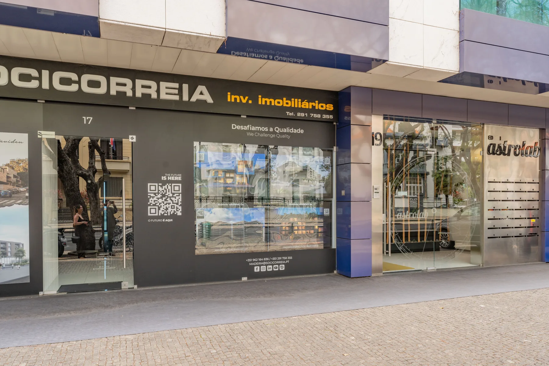 Un local comercial a pie de calle con escaparates de vidrio y una acera.