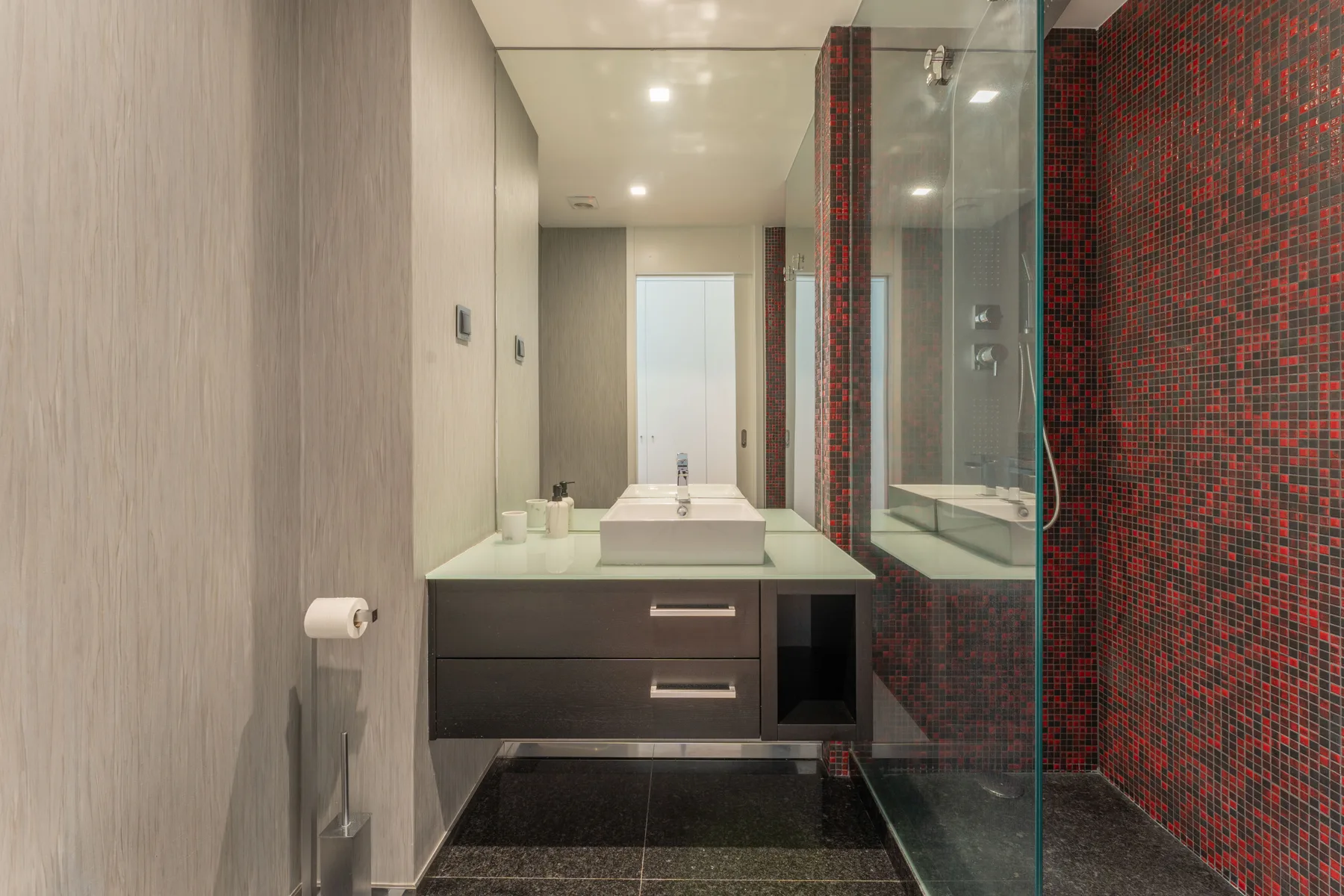 Un baño moderno con lavabo y ducha de vidrio.