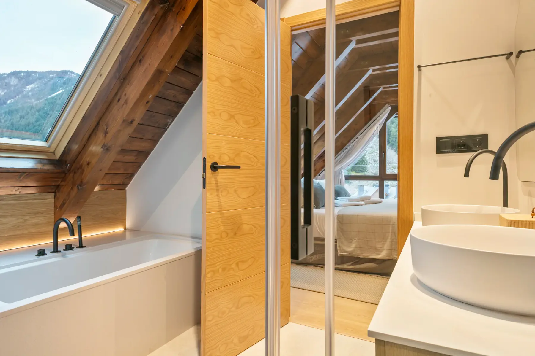 Modern bathroom with a bathtub beneath a sloped window and a vessel sink.