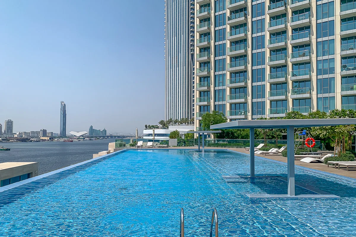 Una piscina en la azotea junto a un edificio alto da al paseo marítimo.