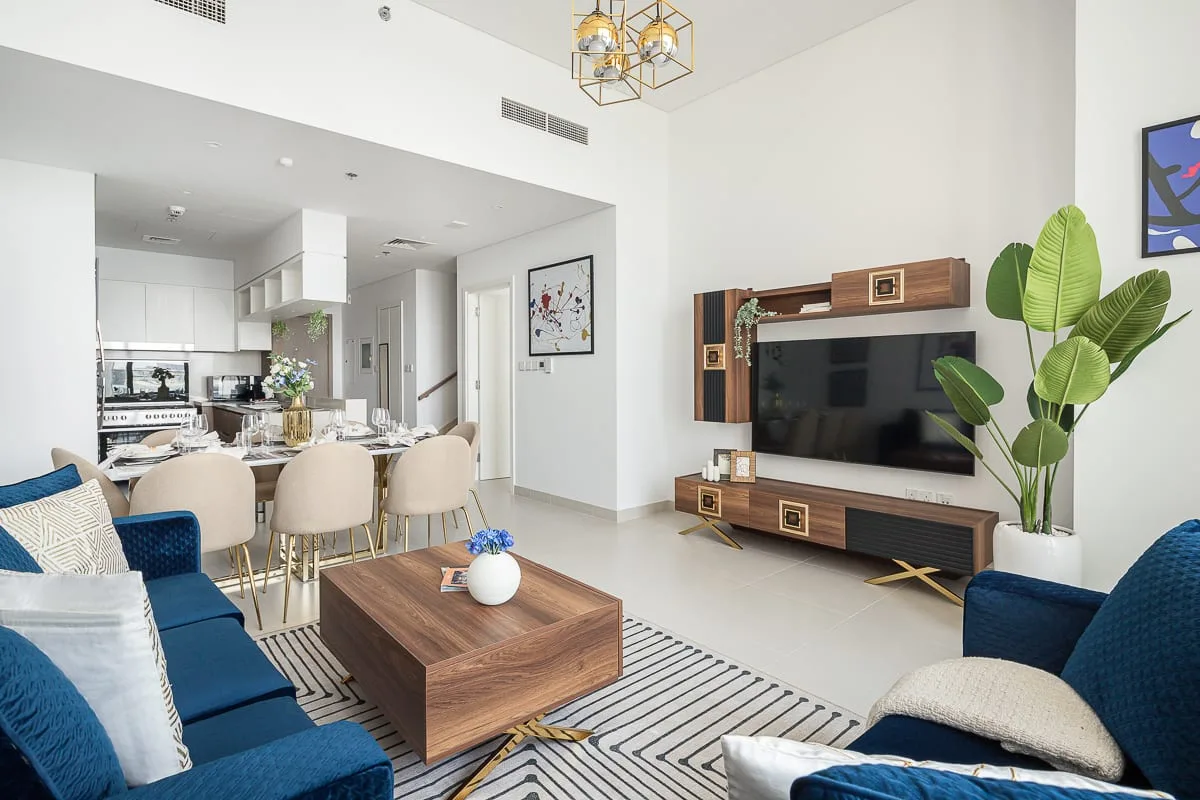 Una luminosa sala de estar y comedor con televisión, asientos y una mesa.