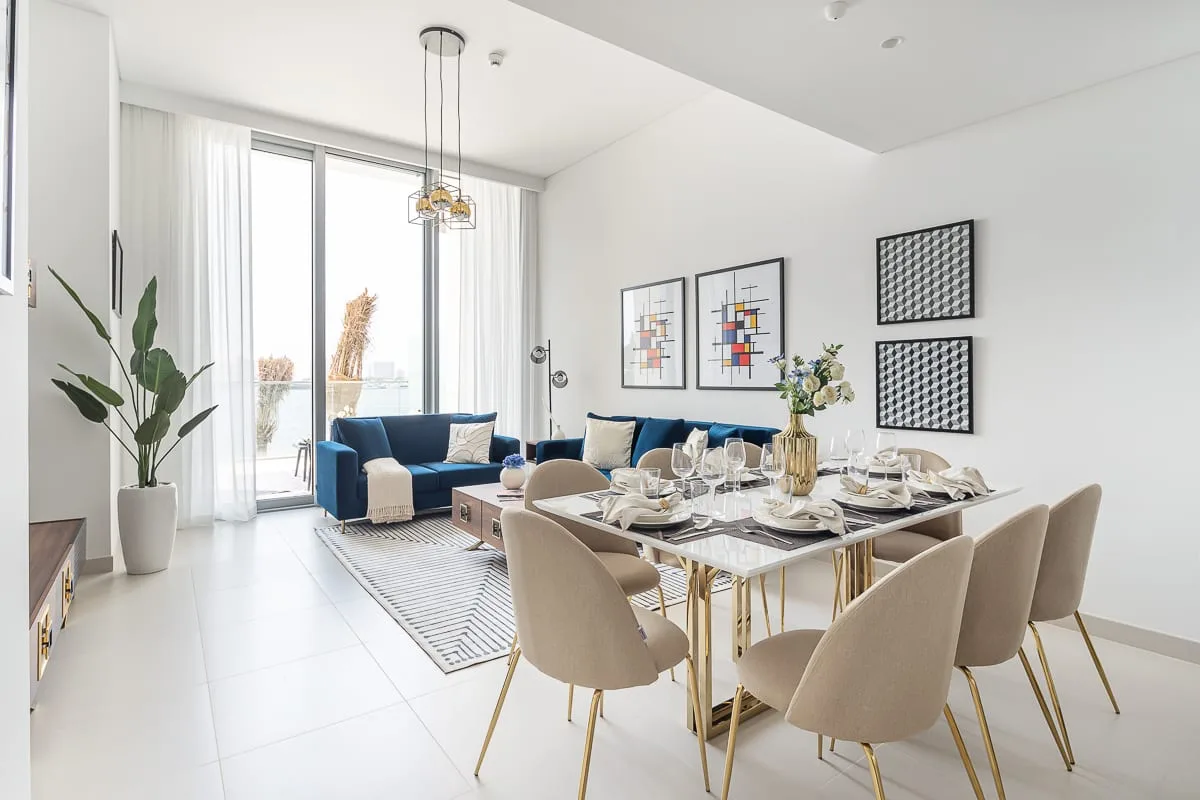 Una luminosa sala de estar y comedor con una mesa junto a una zona de descanso.
