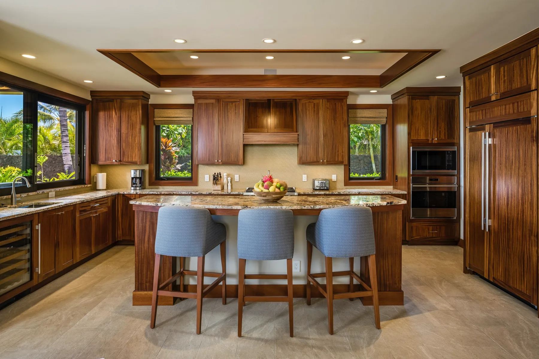 A spacious kitchen with dark wood cabinets and seating at the island.