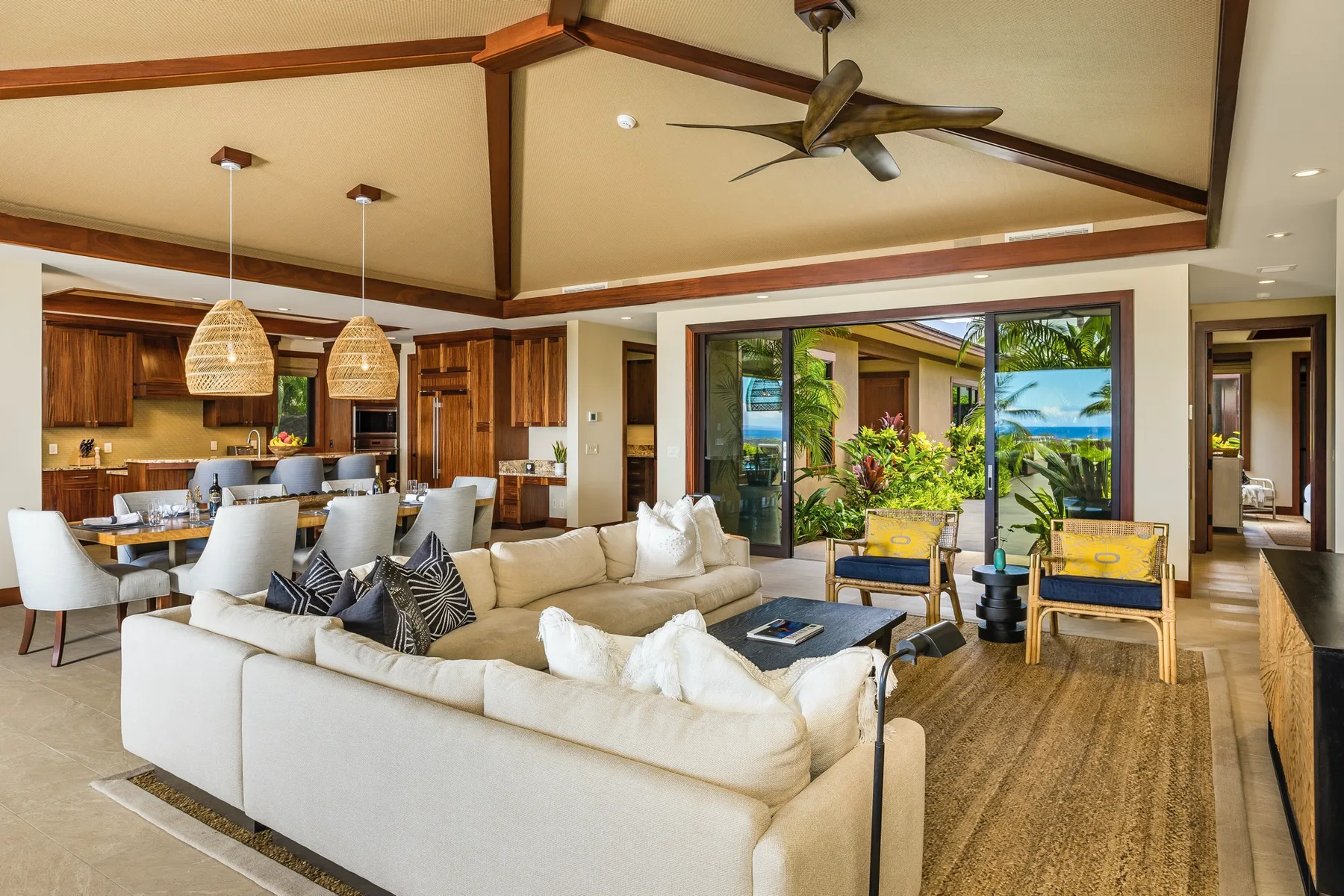 An open-plan living and dining area with seating beside sliding glass doors.