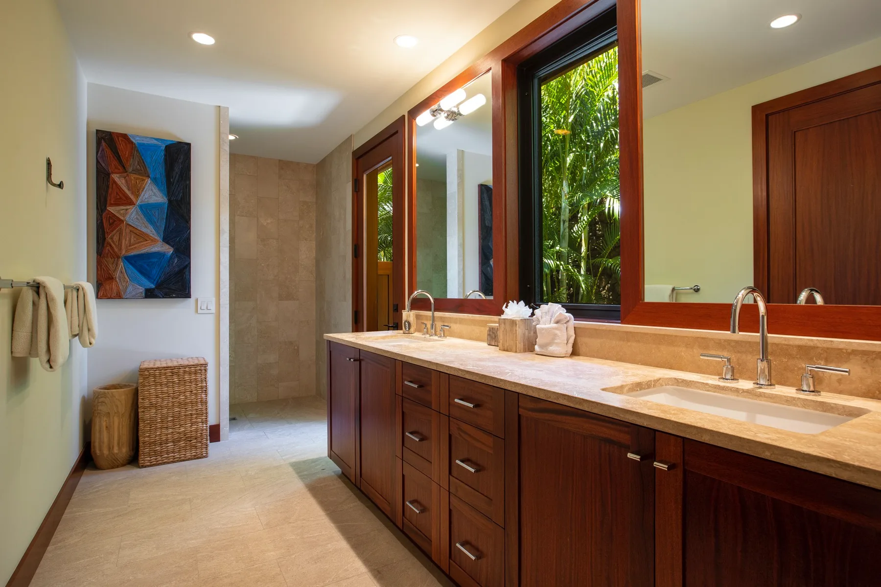 A bathroom vanity with sinks and a large window overlooking greenery.
