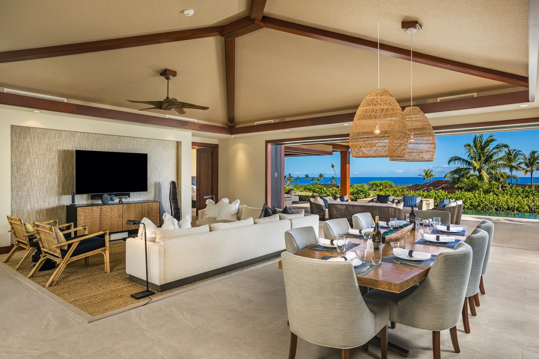 An open-plan living and dining area with seating and a view of the ocean.