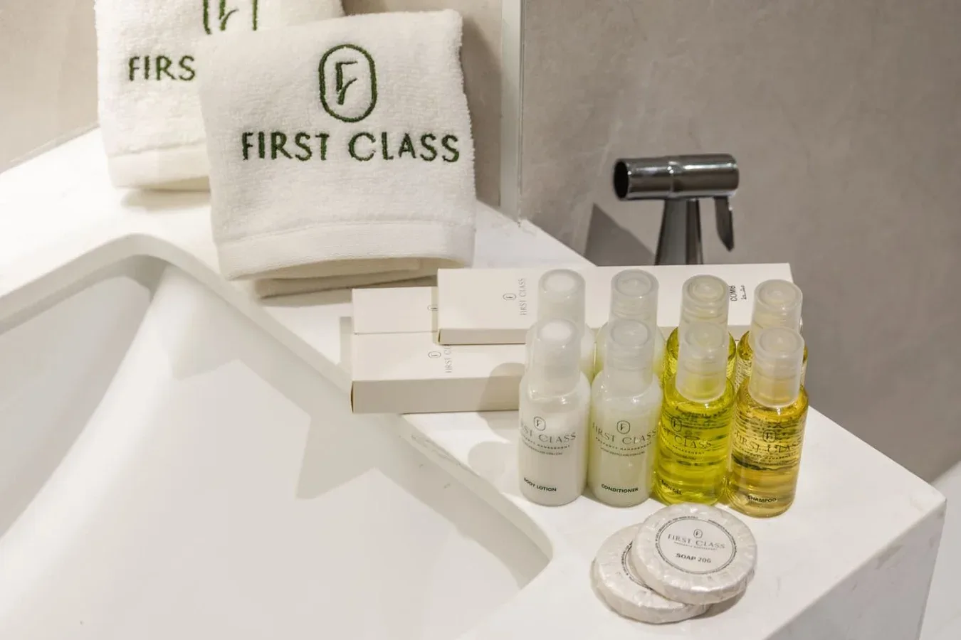 Encimera de baño con toallas dobladas y frascos de artículos de aseo junto al lavabo.