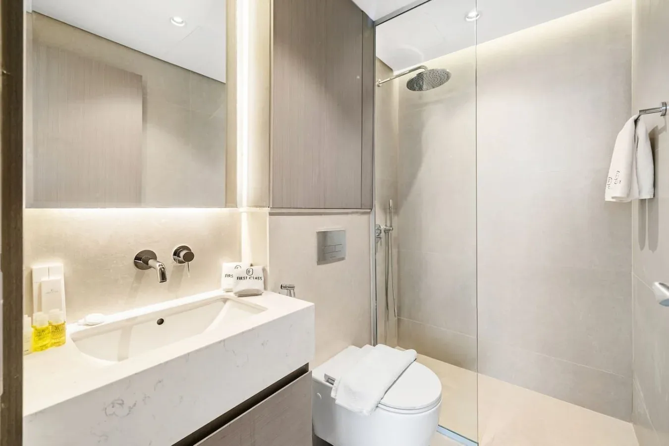 Un baño moderno con lavabo, inodoro y ducha de vidrio.