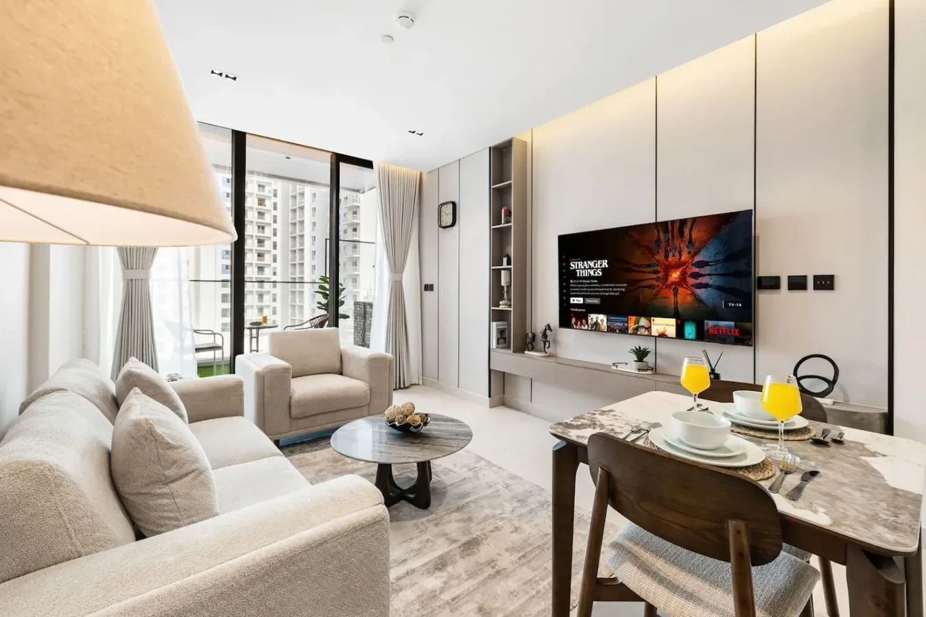 Una sala luminosa con asientos, un televisor y una mesa de comedor.