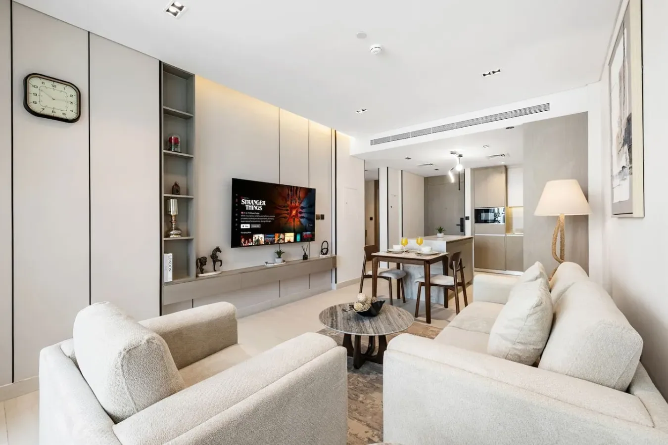 Una sala luminosa con asientos, un televisor y una mesa de comedor.
