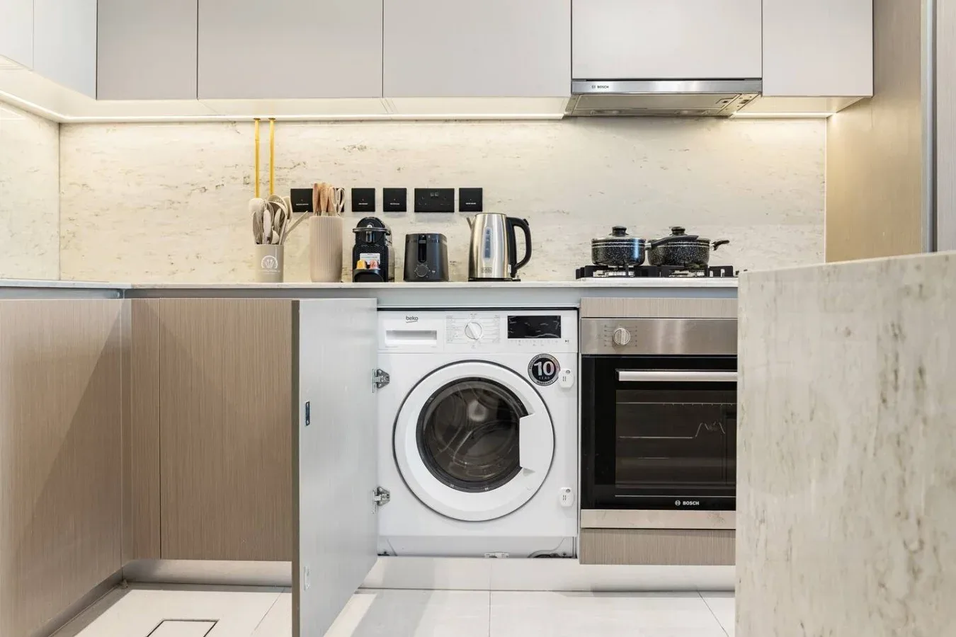 Una cocina moderna con lavadora y horno empotrado.