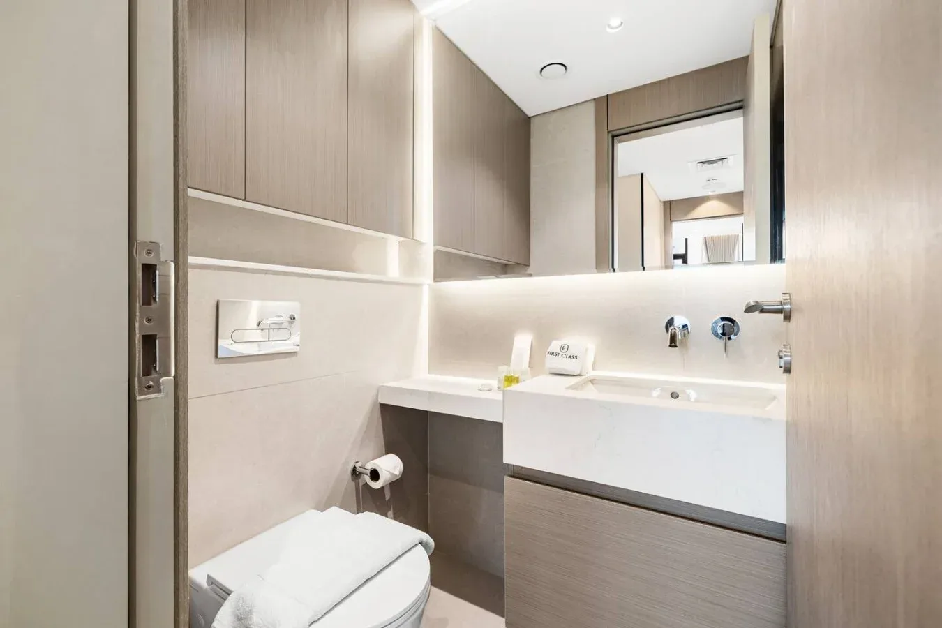 Un baño moderno con un lavabo amplio, un espejo de pared y un inodoro.