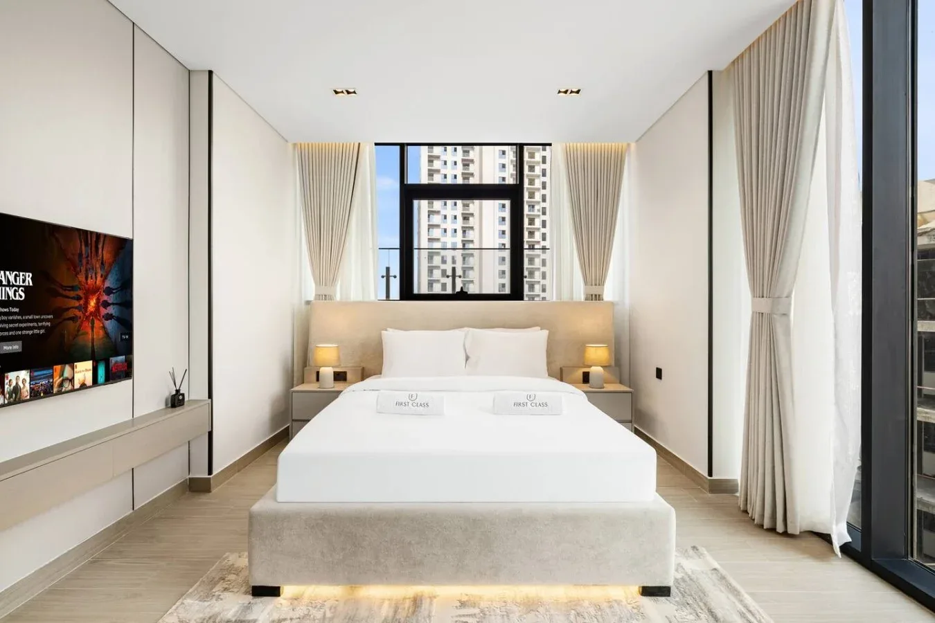 Un dormitorio luminoso con una cama grande bajo una ventana.